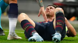 Penyerang Barcelona, Lionel Messi terjatuh di lapangan saat menghadapi Tottenham Hotspur dalam Grup B Liga Champions di Stadion Wembley, London, Rabu (3/10). Messi menyumbang dua gol saat Barcelona membantai Tottenham 4-2. (AP Photo/Frank Augstein)