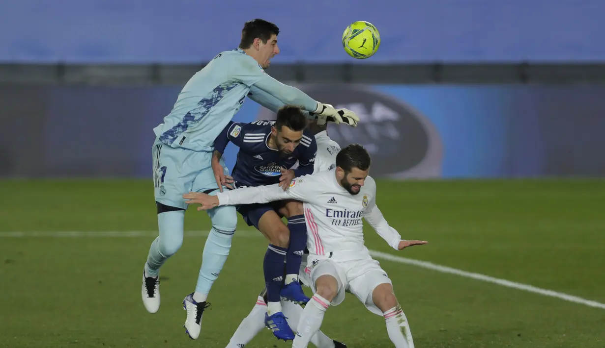 Kiper Real Madrid, Thibaut Courtois berusaha menepis bola dari sundulan pemain Celta Vigo, Brais Mendez  selama pertandingan lanjutan La Liga Spanyol di stadion Alfredo Di Stefano, Minggu (3/1/2021). (AP Photo/Manu Fernandez)