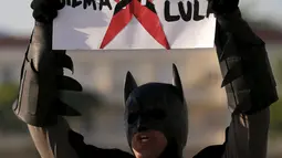 Pria berpakaian Batman membawa spanduk saat unjuk rasa mengecam skandal korupsi yang melanda para politisi dari partai Presiden Rousseff di Sao Paulo, Brasil, Minggu (16/08/2015). (REUTERS/Sergio Moraes)