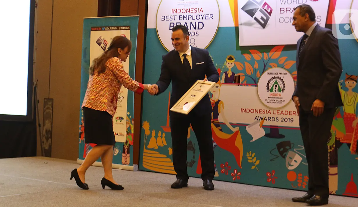 Perwakilan PT Surya Citra Media Tbk (SCM), Helen Melinda (kiri) menerima penghargaan dalam acara Global Brand Excellence Arwards di Jakarta, Kamis (24/10/2019). PT SCM Tbk menerima penghargaan kategori Indonesia Best Brand Awards 2019. (Liputan6.com/Herman Zakharia)
