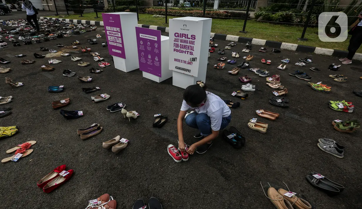 Pegiat komnas perempuan saat melakukan aksi diam 500 Langkah Awal Sahkan RUU PKS di depan gedung DPR, Jakarta, Rabu (25/11/2020). Dalam aksinya mereka menyusun sepatu sebagai simbol "semua peduli, semua terlindungi, stop sexual violence". (Liputan6.com/Johan Tallo)