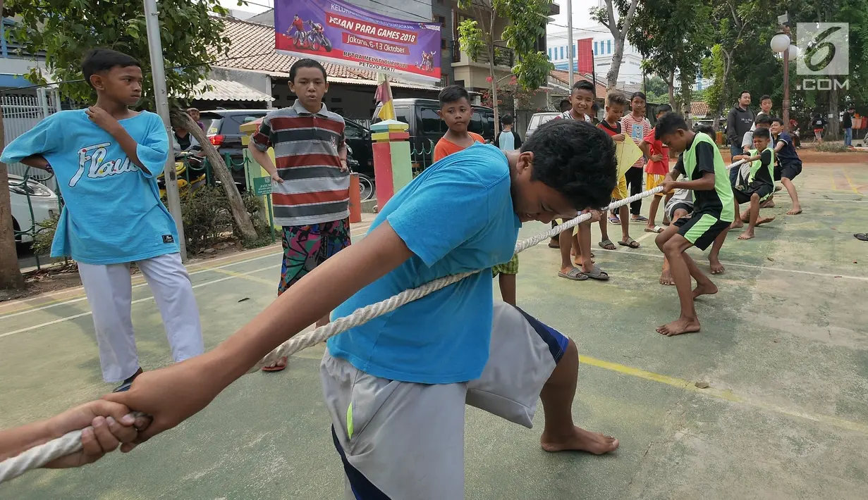 Anak-anak bermain permainan tradisional tarik tambang di RPTRA Melati Duri Pulo, Jakarta, Sabtu (13/10). Traditional Games Returns (TGR) mengampanyekan permainan tradisional Indonesia untuk membangkitkan eksistensinya. (Liputan6.com/Herman Zakharia)
