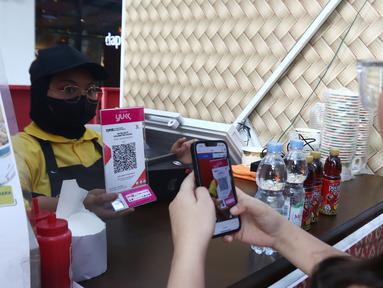 Pembeli melakukan transaksi belanja dengan QRIS di Jakarta, Jumat (28/7/2023). (Liputan6.com/Angga Yuniar)