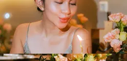 Ariel Tatum merayakan ulang tahun kelima anabul di rumah dengan gaya sederhana: dress satin turquoise, sanggul berhias bunga (@arieltatum)