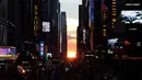 Matahari terbenam di antara pencakar langit, sejajar tepat dengan jalan, ketika fenomena Manhattanhenge di 42nd street di Times Square, New York City, Kamis (12/7). Fenomena ini hanya terjadi selama beberapa hari dalam setahun. (AFP/TIMOTHY A. CLARY)