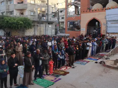 Warga Palestina melaksanakan salat Idul Fitri, yang menandai berakhirnya bulan suci Ramadan, di kamp Nuseirat untuk pengungsi Palestina di Jalur Gaza tengah pada 30 Maret 2025. (Eyad BABA/AFP)