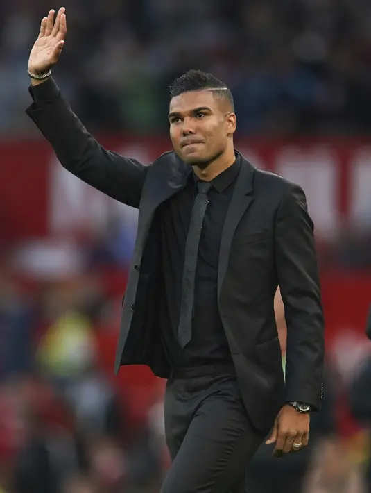 Pemain baru Manchester United Casemiro melambaikan tangan kepada para pendukung ketika diperkenalkan secara resmi sesaat sebelum laga MU vs Liverpool dimulai di stadion Old Trafford, Senin (22/8/2022). Casemiro didatangkan dari Real Madrid dengan mahar 60 juta Euro + 10 juta Euro. (AP Photo/Dave Thompson)