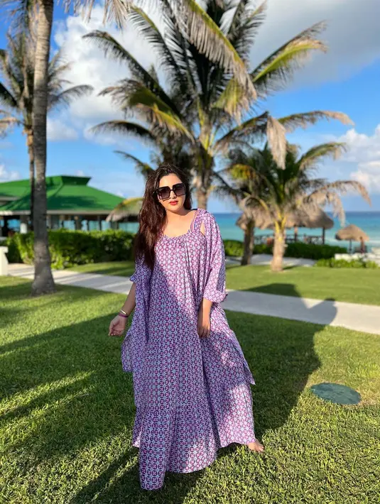 Kali ini dress pantai yang panjang sukses membuat penampilan wanita 37 tahun ini cantik paripurna. Gaun berwarna ungu dengan motif mirip batik ini cocok digunakan untuk bersantai di tempat aga jauh dari air laut. (Liputan6.com/IG/@ashanty_ash)