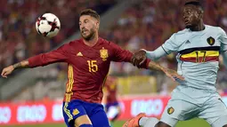 Bek Spanyol, Sergio Ramos, berusaha menahan pergerakan striker Belgia, Divock Origi. Spanyol menguasai jalannya laga dengan penguasaan bola 61 persen. (Reuters/Eric Vidal)