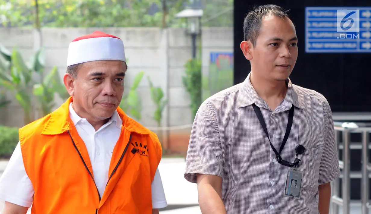 Gubernur Aceh Irwandi Yusuf memakai rompi oranye dikawal petugas saat turun dari mobil tahanan tiba untuk menjalani pemeriksaan lanjutan di gedung KPK, Jakarta, Rabu (25/7). (Merdeka.com/Dwi Narwoko)