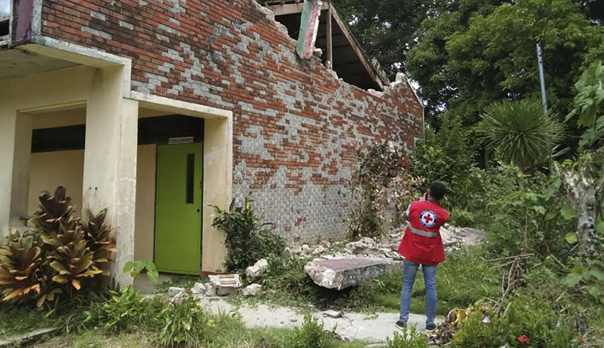 Relawan mengambil foto rumah yang rusak setelah gempa melanda Cataingan, Filipina tengah (18/8/2020). Sejauh ini setidaknya 14 gempa susulan telah dicatat oleh kantor seismologi Filipina, dengan yang terkuat tercatat pada skala M 3,5. (John Mark Lalaguna/Philippine National Red Cross via AP)
