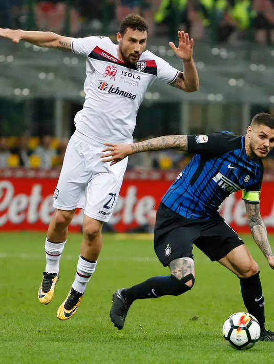 Pemain Inter Milan, Mauro Icardi berebut bola dengan pemain Cagliari,  Artur Ionita pada laga pekan ke-33 Serie A, di Giuseppe Meazza, Selasa (17/4).  Menjamu Cagliari, Inter Milan memetik kemenangan meyakinkan dengan skor 4-0. (AP/Antonio Calanni)
