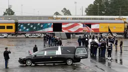Anggota militer membawa peti jenazah Presiden ke-41 AS George HW Bush ke kereta di Union Pacific Westfield, Spring, Texas, Kamis (6/12). Kereta membawa jenazah George HW Bush menuju tempat peristirahatan terakhirnya. (AP Photo/Kiichiro Sato)