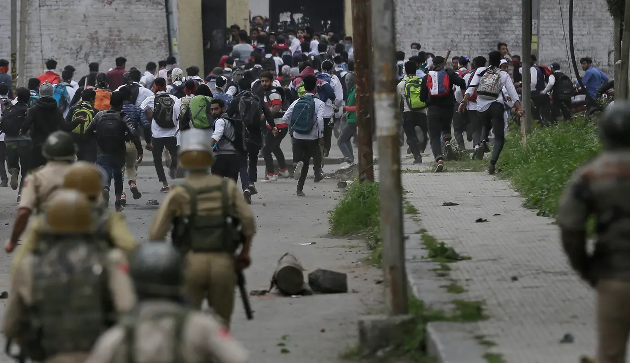 Polisi India mengejar pelajar yang melakukan aksi pelemparan batu di Srinagar, Kashmir, Rabu (17/5). Beberapa bulan belakangan ini keadaan di Kashmir terus diwarnai oleh bentrok antara pelajar dengan polisi. (AP Photo / Mukhtar Khan)