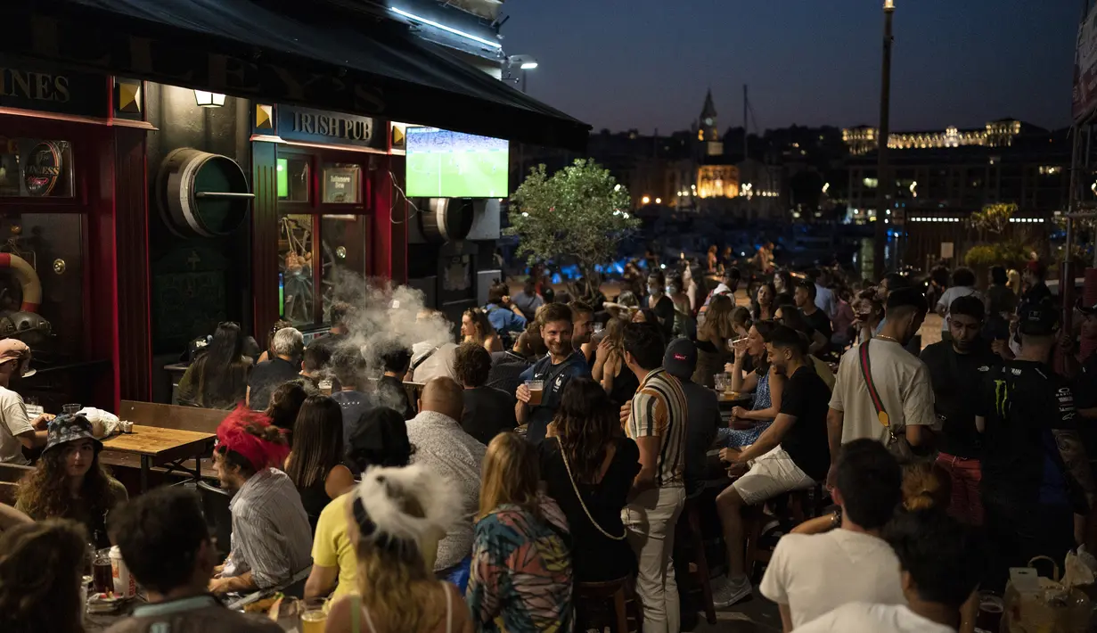 Fans tim Prancis berkumpul di sebuah bar untuk menyaksikan pertandingan grup F kejuaraan sepak bola Euro 2020 antara Prancis dan Jerman yang dimainkan di Munich, di layar televisi di Marseille, Prancis, Selasa (15/6/2021). (AP Photo/Daniel Cole)