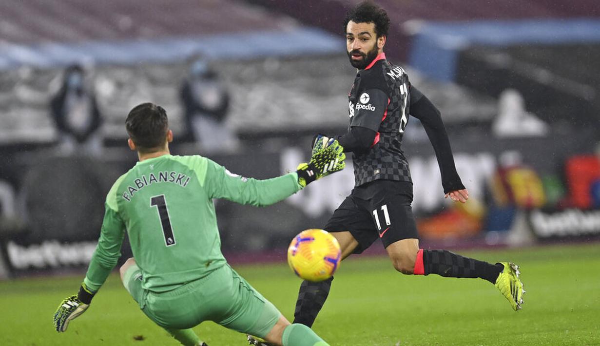 Penyerang Liverpool, Mohamed Salah, mencetak gol ke gawang West Ham United pada laga Liga Inggris di Stadion London, Minggu (31/1/2021). Liverpool menang dengan skor 3-1. (Justin Setterfield/Pool via AP)