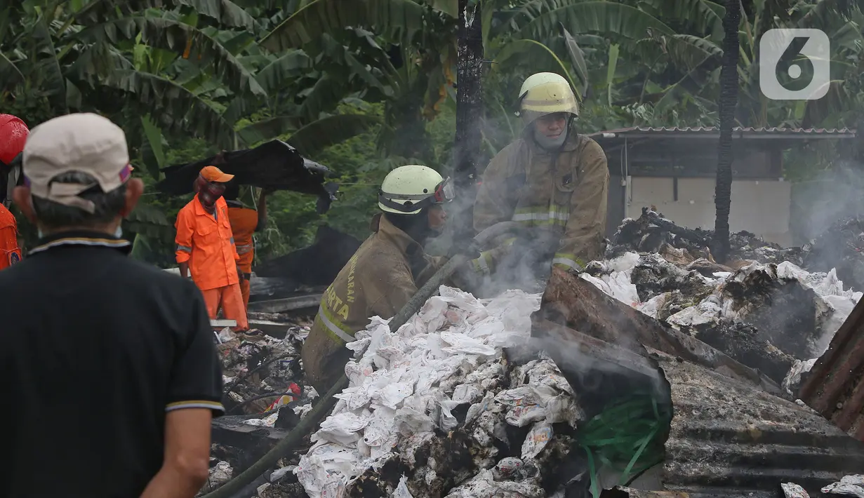 Petugas pemadam kebakaran melakukan pendingin di Pabrik penggilingan kapas,  Pasar Rebo, Jakarta Timur, Selasa (16/11/2021). Sudin Penanggulangan Kebakaran dan Penyelamatan (Gulkarmat) Jakarta Timur menurunkan 13  mobil pemadam kebakaran  untuk memadamkan api. (Liputan6.com/Herman Zakharia)