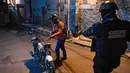 Anggota polisi bersiap menggeledah warga dalam operasi di tengah pandemi COVID-19 di Los Teques, negara bagian Miranda, Venezuela, 20 Maret 2021. Di Miranda ada pembatasan keluar sejak pukul 18.00 dan perintah penutupan toko pada pukul 16.00 di tengah gelombang kedua pandemi. (Federico PARRA/AFP)