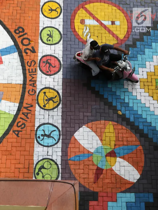 Pengendara melintasi mural yang menghiasi halaman depan Kantor Kelurahan Tegal Alur, Jakarta Barat, Rabu (18/4). Keberadaan mural memperindah Kantor Kelurahan Tegal Alur. (Liputan6.com/Arya Manggala)