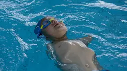Ismail Zulfic saat latihan berenang di kolam renang Olimpiade di Sarajevo, Bosnia (8/6). Ismail berlatih renang untuk memenangkan kompetisi regional perenang cacat di Bosnia. (AP Photo/Amel Emric)
