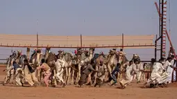 Petugas Sudan bergegas keluar dari trek menjelang balapan unta di dekat desa al-Ikhlas, barat kota Omdurman, 19 Maret 2021. Perlombaan diselenggarakan oleh keluarga suku tradisional yang memelihara unta dari desa setempat untuk melestarikan dan merayakan warisan budaya mereka. (ABDULMONAM EASSA/AFP)