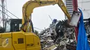 Alat berat mengangkat sebuah motor yang hancur tertimpa puing bangunan PHD, Kota Bekasi, Minggu (23/10). Satu unit eskavator milik Dinas Bina Marga dan Tata Air (Disbimarta) Kota Bekasi dipinjamkan ke lokasi ledakan. (Liputan6.com/Yoppy Renato)