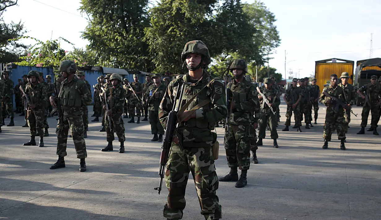 Tentara Nikaragua berjaga di luar gedung bea cukai di perbatasan antara Nikaragua dan Kosta Rika, Minggu (15/11). Nikaragua menutup perbatasannya dengan Kosta Rika hingga menyebabkan ribuan orang yang menuju Amerika terlantar. (REUTERS/Oswaldo Rivas)