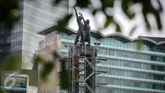 Pekerja memasang penyangga dan kawat baja pada Patung Selamat Datang di Bundaran HI, Jakarta, Jumat (25/3). Pemasangan tersebut bertujuan untuk menjaga patung dari goncangan ketika bor Antareja melintasi kawasan Bundaran HI. (Liputan6.com/Faizal Fanani) 