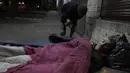 Vicente Franco tidur di atas kasur dan ditutupi selimut sumbangan di atas trotoar di Asuncion, Paraguay, Jumat (2/7/2021). Menurut direktur National Emergency Office, jumlah tunawisma telah meningkat di tengah pandemi virus corona COVID-19. (Ap Photo/Jorge Saenz)