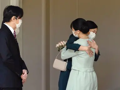 Putri Mako dari Jepang memeluk saudara perempuannya Putri Kako sebelum meninggalkan rumahnya di Istana Akasaka, Tokyo, Selasa (26/10/2021). Putri Mako secara resmi kehilangan status kerajaannya setelah menikahi kekasih semasa kuliah, Kei Komuro pada Selasa (26/10). (Koki Sengoku/Kyodo News via AP)