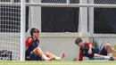 Pemain Timnas Spanyol U-17, Marc Guiu (kiri), mencari tempat teduh saat menjalani latihan dibawah sinar terik matahari yang berlangsung di Lapangan Sriwaru, Kecamatan Laweyan, Kota Solo, Rabu (8/11/2023). (Bola.com/Radifa Arsa)