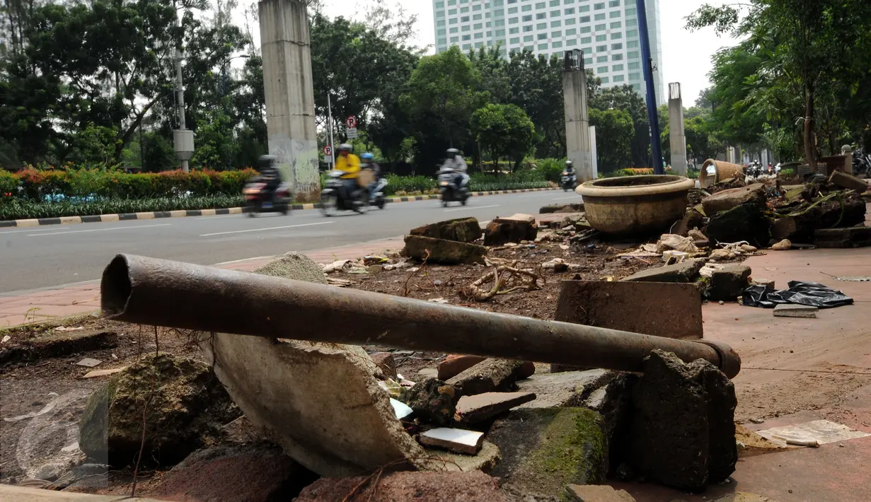 Alat kerja pertanian tergeletak di trotoar Jalan Asia Afrika, Jakarta, Selasa (24/5/2016). Pasca pembongkaran lapak pedagang tanaman pekan lalu, sisa pembongkaran masih terlihat dan membuat trotoar terlihat berantakan. (Liputan6.com/Helmi Fithriansyah)