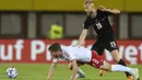 <p>Gelandang Austria, Konrad Laimer berebut bola dengan pemain Denmark, Joakim Mahle pada pertandingan UEFA Nations League di Stadion Ernst Happel di Wina, Austria, Selasa (7/6/2022). Denmark menang tipis atas Austria 2-1. (AP Photo/Andreas Schaad)</p>