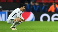 Striker Tottenham Hotspur, Son Heung-Min berjongkok di lapangan saat menjamu Juventus pada leg kedua babak 16 besar Liga Champions di Wembley, Kamis (8/3). Kekalahan dari Juventus membuat Heung-Min terlihat begitu emosional. (Glyn KIRK/AFP)