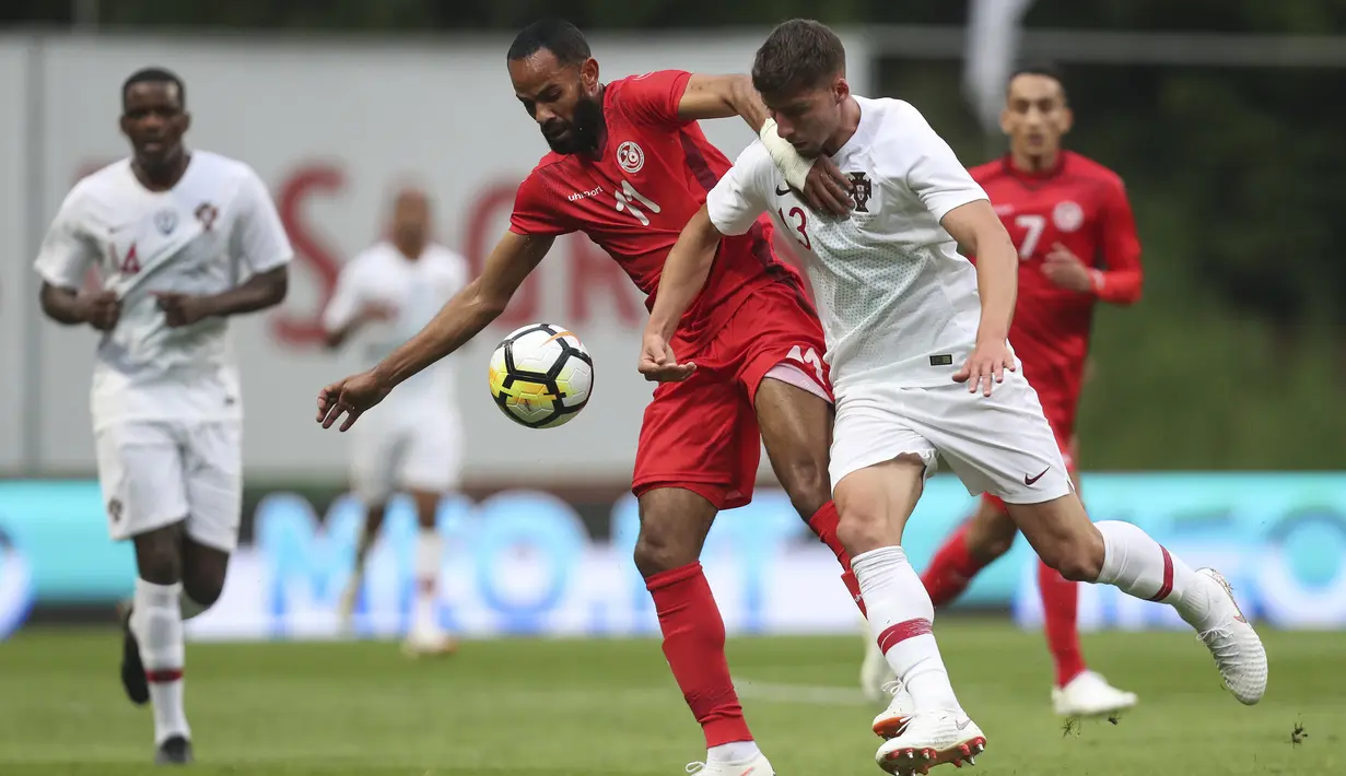 Pemain Tunisia, Saber Khalifa (tengah) berebut bola dengan pemain Portugal, Ruben Dias pada laga uji coba di Estadio Municipal de Braga, (28/5/2018) waktu setempat. Portugal dan Tunisia bermain imbang 2-2. (AP/Luis Vieira)