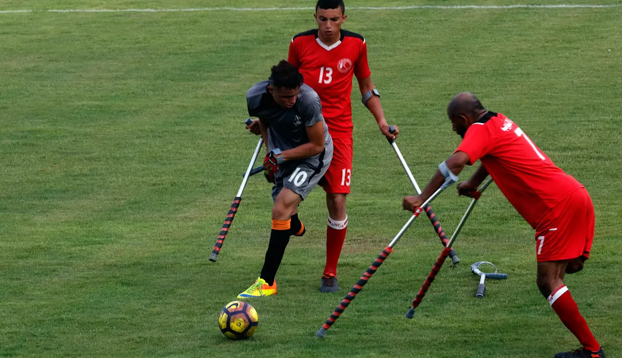 Warga Palestina yang diamputasi berebut bola selama pertandingan  di stadion Kota Gaza, Selasa (27/8/2019). Turnamen lokal tersebut diadakan pertama kali bagi orang-orang Palestina yang kehilangan anggota tubuhnya akibat tembakan Israel di Jalur Gaza. (AP Photo/Hatem Moussa)
