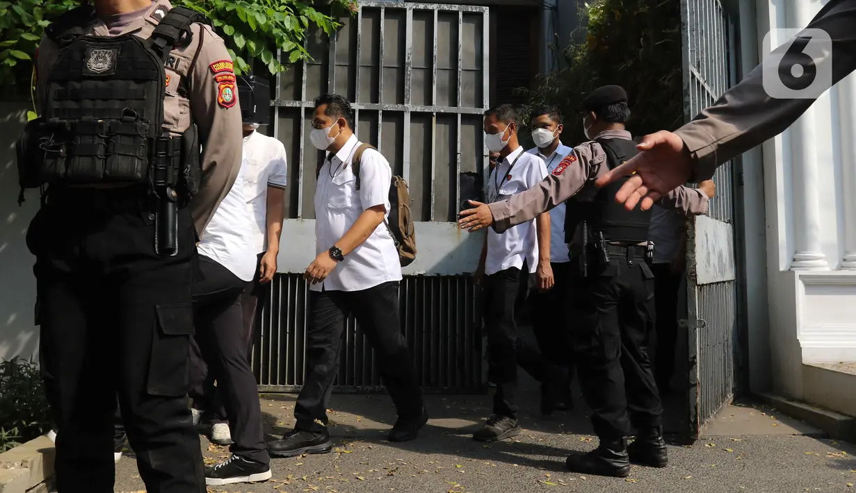 Sejumlah penyidik berseragam kemeja putih keluar dari rumah yang memiliki pagar berwarna abu itu. (Liputan6.com/Herman Zakharia)