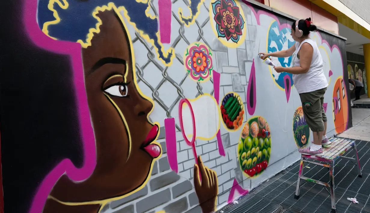 Seniman grafiti Sandra Fabara atau lebih dikenal Lady Pink melukis mural di Casita Maria, Bronx, New York, AS, Minggu (2/6/2019). Lady Pink mulai melukis grafiti pada usia 15 tahun. (Don Emmert/AFP)