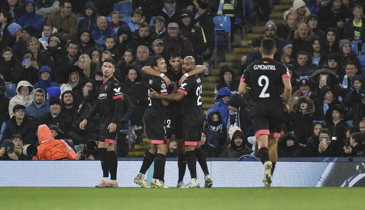 Pemain Sevilla, Rafa Mir (tengah) merayakan dengan rekan setimnya setelah mencetak gol ke gawang Manchester City selama pertandingan lanjutan Grup G Liga Champions di stadion Etihad di Manchester, Inggris, Kamis (3/11/2022). Man City menang atas Sevilla dengan skor 3-1. (AP Photo/Rui Vieira)