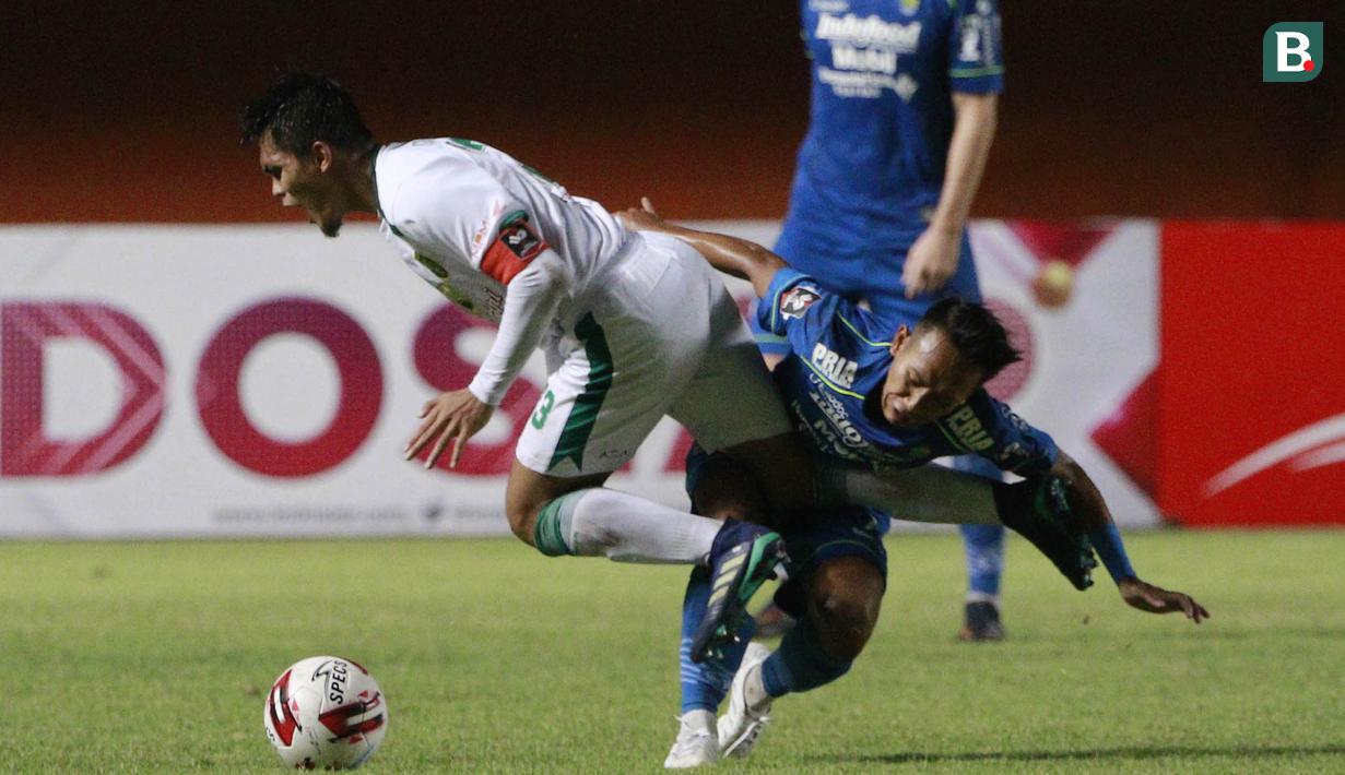 Gelandang Persib Bandung, Beckham Putra (kanan) berebut bola dengan bek Persebaya Surabaya, Rachmat Irianto dalam laga perempatfinal Piala Menpora 2021 di Stadion Maguwoharjo, Sleman, Minggu (11/4/2021). Persib menang 3-2 atas Persebaya. (Bola.com/M Iqbal Ichsan)