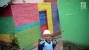 Seorang bocah menyusuri jalan di Kampung Warna Warni Lubuklinggau, Sumatera Selatan, Rabu (10/1). Jika sebelumnya dikenal sebagai kampung kriminal, kini Kampung Warna Warni Lubuklinggau dikenal sebagai lokasi wisata. (Liputan6.com/Immanuel Antonius)