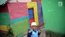 Seorang bocah menyusuri jalan di Kampung Warna Warni Lubuklinggau, Sumatera Selatan, Rabu (10/1). Jika sebelumnya dikenal sebagai kampung kriminal, kini Kampung Warna Warni Lubuklinggau dikenal sebagai lokasi wisata. (Liputan6.com/Immanuel Antonius)