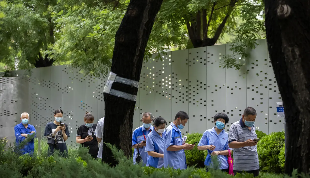 Orang-orang yang memakai masker antre untuk tes COVID-19 di tempat pengujian virus corona di Beijing, Rabu (6/7/2022). Lockdown dan pengujian massal berulang kali terjadi di China. Ini merupakan bagian dari kebijakan nol-Covid yang bertujuan untuk memberantas semua wabah. (AP Photo/Mark Schiefelbein)
