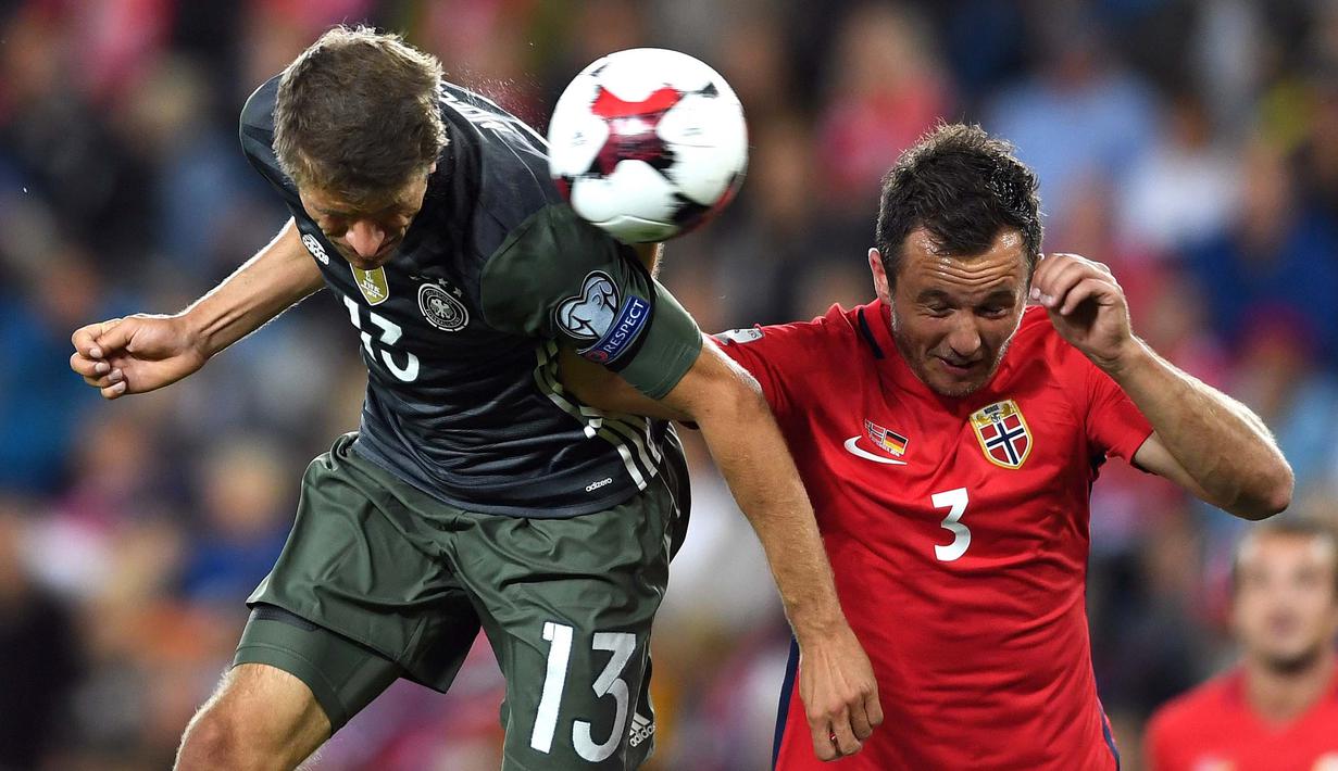 Pemain Jerman,Thomas Mueller (kiri) berduel dengan pemain Norwegia, Even Hovland pada kualifikasi grup C piala dunia 2018 di Stadion Ullevaal, Oslo, Norwegia, (5/9/2016) dini hari WIB.  (EPA/Federico Gambarini)