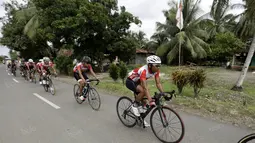 Tim Indonesia  melewati halaman rumah warga yang memajang bendera Merah-Putih menyambut HUT RI ke-71 pada ajang balapa Tour de Singkarak 2016 di Sumatera Barat, (11/8/2016). (Bola.com/Nicklas Hanoatubun)
