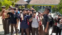 Para siswa SDN I Wegil terpaksa menutup hidungnya akibat dikepung hujan debu akibat aktivitas tambang batu kapur Pegunungan Kendeng. (Liputan6.com/Arief Pramono)