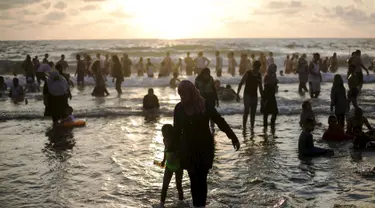 Sejumlah warga Palestina menikmati liburan di pantai Tel Aviv, Israel, Minggu (19/7/2015). Selama Idul Fitri, pemerintah Israel mengizinkan warga Palestina untuk berwisata di sepanjang garis pantai Mediterania. (REUTERS/Baz Ratner)