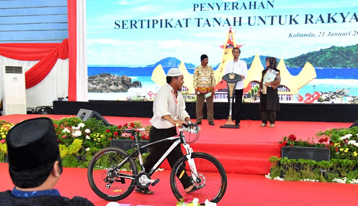 Warga membawa hadiah sepeda yang diberikan oleh Presiden Jokowi saat membagikan sertifikat di GOR Way Handak, Kalianda, Lampung Selatan, Lampung, Minggu (21/1). (Liputan6.com/Pool/Laily Rachev-Biro Pers Setpres)