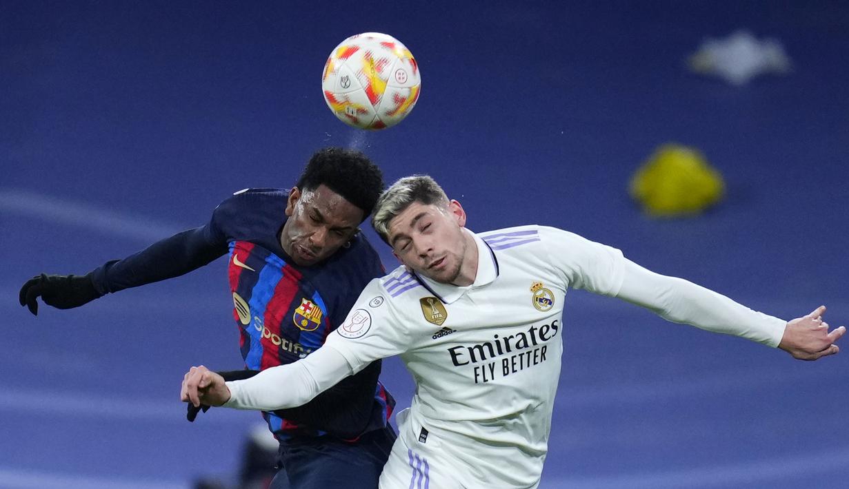 Pemain Barcelona, Alejandro Balde (kiri) berduel udara dengan pemain Real Madrid, Federico Valverde pada laga leg pertama semifinal Copa Del Rey 2022/2023 di Santiago Bernabeu, Madrid, Jumat (03/03/2023) WIB. Laga berakhir dengan skor 1-0 untuk kemenangan Barcelona. (AP Photo/Manu Fernandez)