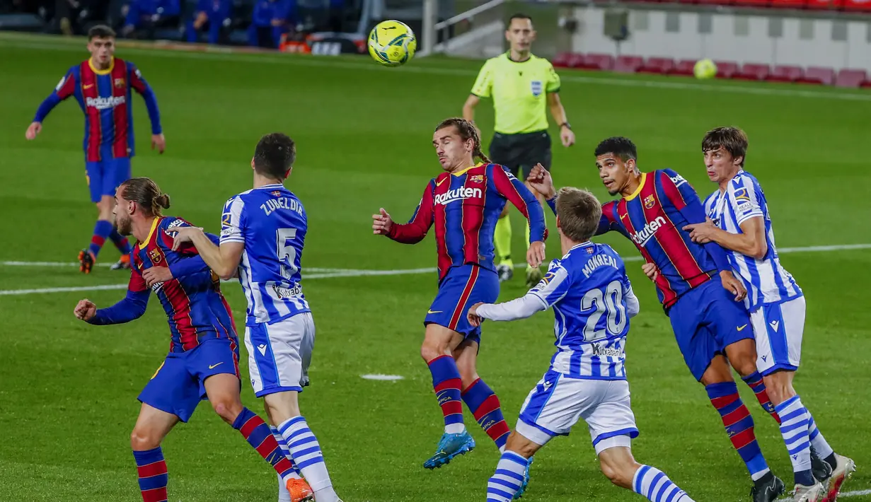 Penyerang Barcelona, Antoine Griezmann berusaha menyundul bola saat berhadapan dengan Real Sociedad pada pertandingan La Liga Spanyol di stadion Camp Nou di Barcelona, Spanyol, Kamis (17/12/2020). Aksi Griezmann dengan kepang duanya diselingi dengan performa yang lumayan. (AP Photo/Joan Monfort)